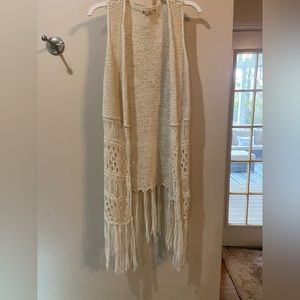 tan/beige sleeveless cardigan with fringe at the end